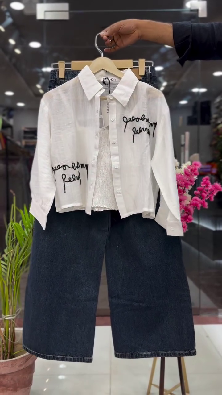 Modern White Cropped Button Down Shirt with Black Script Print Layered Over Inner Top and Dark Blue Wide Leg Denim Set