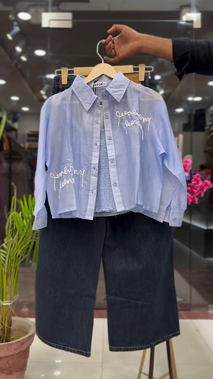 Modern White Cropped Button Down Shirt with Black Script Print Layered Over Inner Top and Dark Blue Wide Leg Denim Set